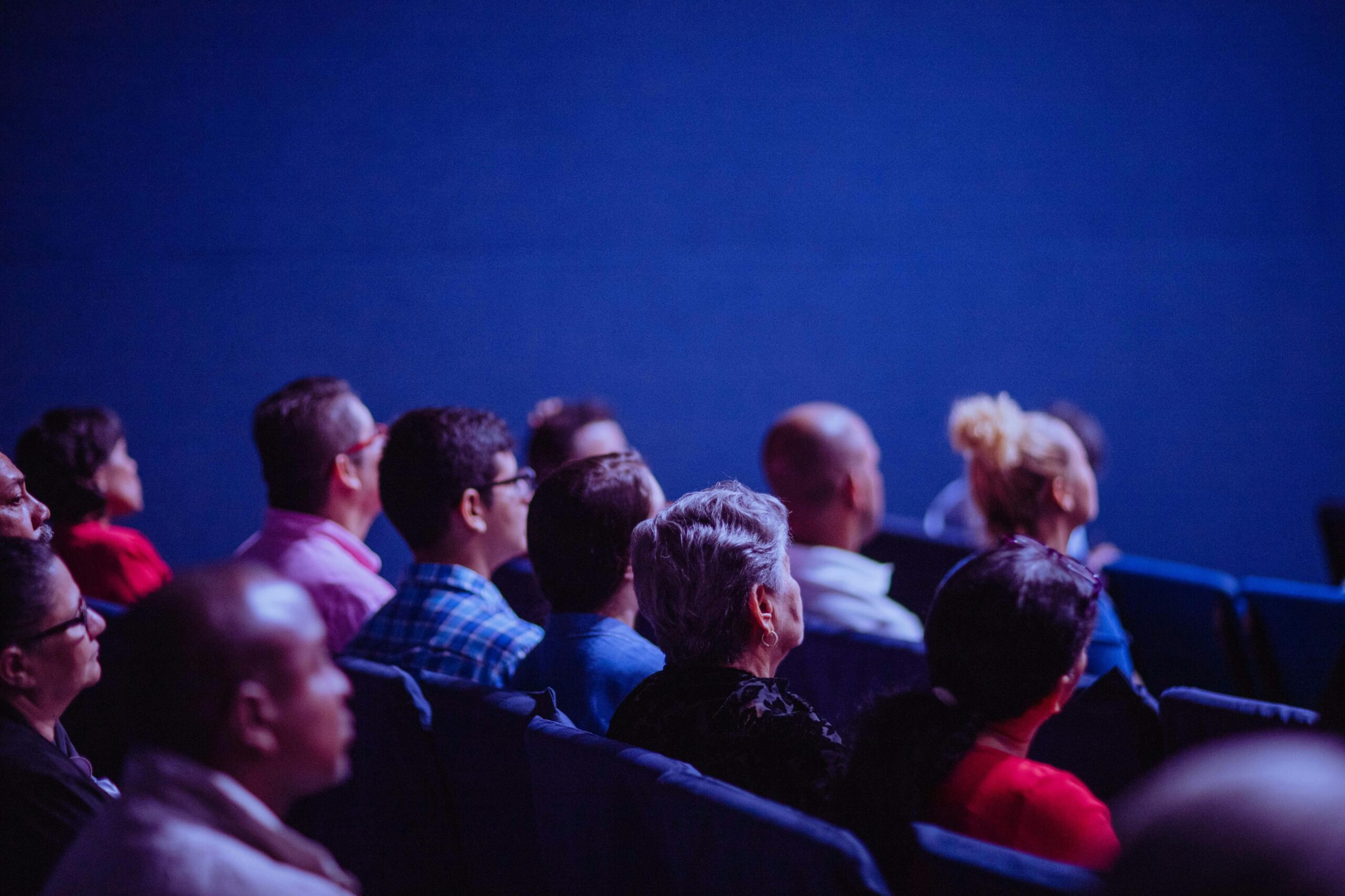 People sitting in an auditorium listening.