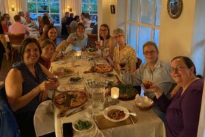 Eight WCEA partners sitting around a dining table in a restaurant.
